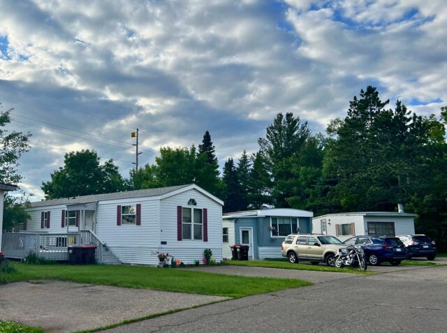 Braham MHC houses with cars and motorcycles parked in driveways